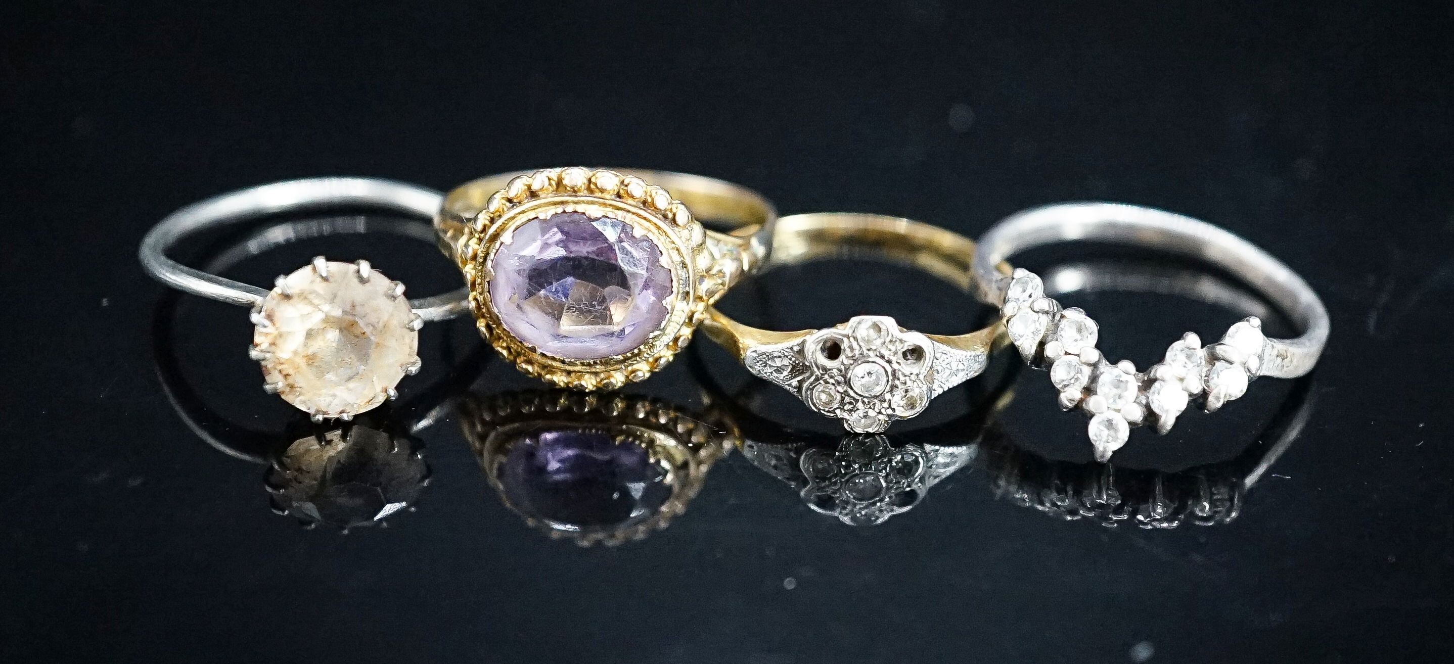 A Victorian yellow metal and amethyst dress ring (shank a.f.), gross 2.6 grams, size P/Q, a small diamond set ring(a.f.), gross 1.8 grams and two paste rings.